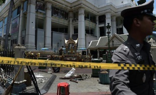 Un policier thaïlandais patrouille près du cordon de sécurité entourant le site d'un attentat contre un temple hindouiste, dans un quartier touristique et commercial de Bangkok, le 18 août 2015