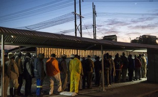 Des mineurs font la queue devant la mine de platine de Marikana, en Afrique du Sud, le 25 juin 2014