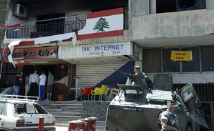 Des soldats de l'armée libanaise dans leur blindé montent la garde devant les bureaux incendiés du Mouvement Arabe après une nuit d'affrontements à Beyrouth (lundi 21 mai 2012)