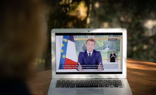 Une femme regarde l'allocution du président Macron, dimanche 14 juin.