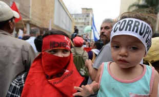 Un enfant porte un bandeau dénonçant la corruption, lors d'une manifestation à Tegucigalpa le 3 juin 2015 pour réclamer la démission du président hondurien Juan Orlando Hernandez