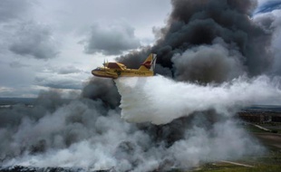 Un hydravion largue de l'eau sur une décharge sauvage de pneus en feu, près de Seseña en Espagne le 13 mai 2016
