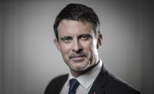 Former French Prime Minister and member of parliament Manuel Valls looks at his mobile phone as he poses in his office during a photo session in Paris on December 20, 2017.
JOEL SAGET / AFP