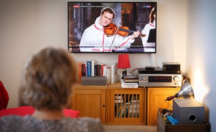 Le 10 avril 2020, en plein confinement, une femme regarde la célébration du Vendredi Saint se déroulant dans la cathédrale Notre-Dame de Paris et retransmise en direct à la télévision.