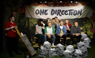 Une employée du musée de cire Madame Tussauds, à Londres, apporte des mouchoirs devant les statues des membres de One Direction, le 31 mars 2015.