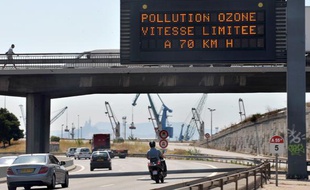 Des automobilistes circulent sous un panneau de limitation de la vitesse, réduite à 70km/h en raison de la canicule qui augmente les risques de pollution à l'ozone, sur l'autoroute du Littoral à Marseille, le 18 août 2009.