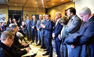 Le ministre de l'Economie Emmanuel Macron (C) aux côtés d'investisseurs américains à l'extérieur des locaux du groupe verrier français Arc International, le 24 décembre 2014 à Arques