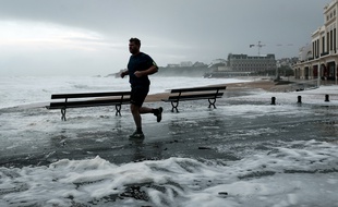 Un homme court au bord de la mer sur la Grande Plage de Biarritz, dans le sud-ouest de la France, le 3 novembre 2019, lors de la tempête Amélie.