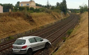 La voiture a été abandonnée par son conducteur sur la voie ferrée.