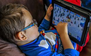 Un enfant jouan sur une tablette.