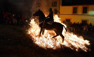 L'un après l'autre, les chevaux et leurs cavaliers s'élancent par-dessus les bûchers qui jalonnent les rues étroites de San Bartolome de Pinares, un village du centre de l'Espagne, dans un ballet avec le feu qui se répète depuis des centaines d'années.