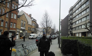 Des policiers belges bloquent l'accès où se déroule l'assaut dans le quartier de Molenbeek à Bruxelles, en Belgique le 18 mars 2016.