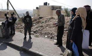 Des policiers israéliens et des Palestiniens près du quartier de Jabal Mukaber, à Jérusalem-Est, le 18 novembre 2014