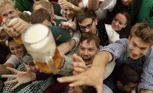 Des jeunes trinquent à la bière lors de l'ouverture du 184e Oktoberfest à Munich en Allemagne, samedi 16 septembre 2017.