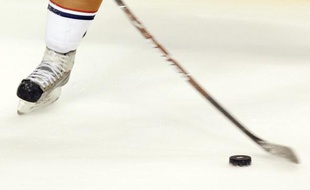 Un patin à glace, une crosse et un palet. Tout ce qu'il faut pour jouer au hockey.