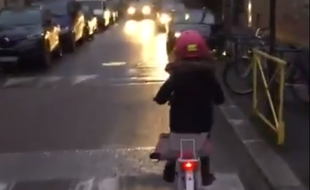 Capture d'écran de la vidéo montrant une enfant à vélo slalomant entre les voitures.