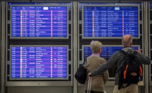 Des voyageurs contrôlent les écrans d'informations sur les vols à l'aéroport de Francfort, en Allemagne, le 9 novembre 2015