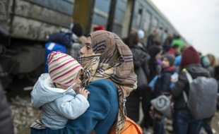 Des migrants embarquent à bord d'un train à destination de la Serbie le 18 février 2016 près de Gevgelija à la frontière entre la Macédoine et la Grèce