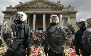 La police belge protège le mémorial en hommage aux victimes des attentats place de la Bourse à Bruxelles.