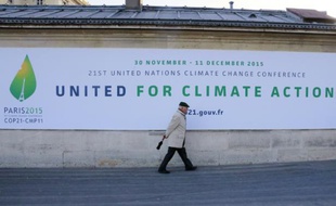 Un homme passe devant un panneau annonçant la tenue de la conférence de Paris (COP 21) sur le climat, le 14 janvier 2015