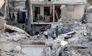 Des habitants sur les ruines de bâtiments détruits par des frappes du régime syrien à Alep, le 28 octobre 2014