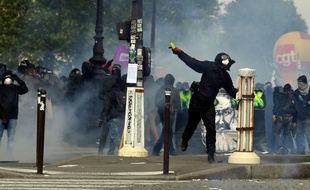 Un manifestant lance un projectile aux forces de l'ordre, lors du défilé du 1er-mai à Paris.