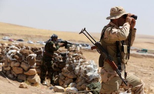 Des kurdes irakiens surveillent le front le 12 août 2014, au nord-est de Mossoul, où ils combattent les troupes de l'Etat islamique