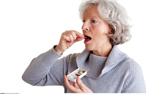 Une dame âgée prenant des médicaments.
