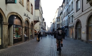 Un vélo à faible allure dans la Grand'rue en plein centre de Strasbourg.