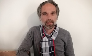 Romain Manci avec l'écharpe solidaire autour du cou.