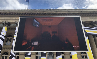 Un écran géant devant la Bourse de Paris diffuse en direct la finalisation de l'album de Kanye West.
