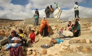 Une famille palestinienne près des ruines de sa maison, détruite par les autorités israéliennes, le 2 février 2016 dans le village de Khirbet Jenbah, au sud d'Hébron