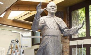 L'artiste Elisabeth Cibot au côté de l'imposante statue de Jean Paul II.