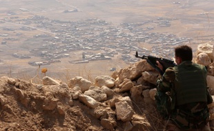 Un combattant kurde surveille les alentours depuis le sommet du mont Zardak, à environ 25 kilomètres à l'est de Mossoul, le 6 août 2015