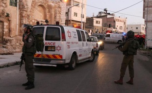 Des ambulances et des membres des forces de sécurité israéliennes, le 14 février 2016 à Hébron en Cisjordanie