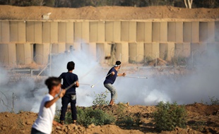 Des Palestiniens manifestent devant le mur qui sépare Gaza d'Israël le 26 juillet 2019