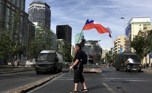 Un manifestant face aux forces de l'ordre à Santiago du Chili, le 26 octobre 2019.