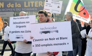 Employees of the Technicolor company demonstrate with a placard reading "The future in black and white, 350 jobs threatened !" on March 13, 2012 in front of their plant in the western city of Angers, to protest againt the foreseen closure of the company. Three hundred and 50 jobs would be cut in the case of closure. AFP PHOTO FRANK PERRY