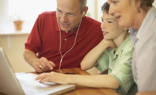 Des grands-parents jouent avec leur petit-fils sur le web.