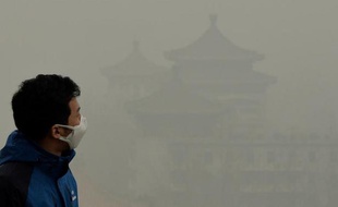 Un touriste porte un masque pour se protéger contre le nuage de pollution qui enveloppe Pékin, le 26 février 2014, ville chinoise qui comme de nombreuses autres dans le pays souffre d'un taux de pollution anormalement élevé