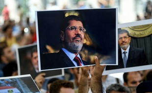 Des gens tiennent une photo du président égyptien Mohamed Morsi lors d'une cérémonie commémorative de funérailles symbolique le 18 juin 2019 à la mosquée Fatih à Istanbul.