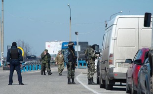 Des soldats russes font des contrôles de véhicules dans le district de Henichesk sur la route de Tchongar, l'une des seules routes reliant la Crimée à l'Ukraine