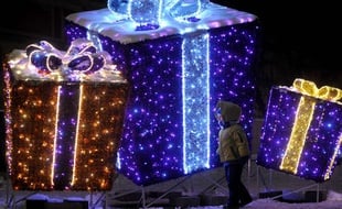 A child walk past a Christmas decoration resembling gifts on the Zamkowy Square in Warsaw, Poland, Sunday, Dec 23, 2012, one day ahead of Christmas Eve. (AP Photo/Alik Keplicz)/XAK151/709004918200/1212232016
