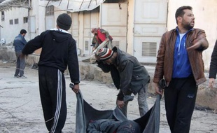 Des rebelles transportent le corps d'une victime à Alep, le 8 janvier 2014