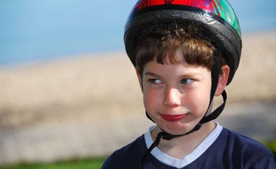 Photo d'illustration: Un jeune garçon porte un casque de vélo.