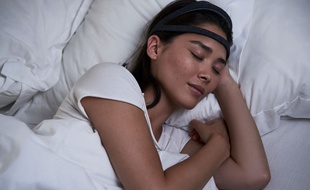 Une femme dort avec le bandeau Dreem, illustration.