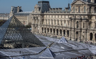 Dans la Cour Napoléon du Louvre, des volontaires s'affairaient à coller vendredi 29 mars 2019 les derniers lés de papier du collage géant de JR.
