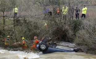 Des sauveteurs près d'une voiture dans laquelle ont péri une mère et ses deux enfants près de Cruviers-Lascours, le 15 novembre 2014