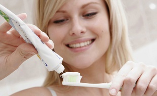 Illustration d'une jeune femme sur le point de se brosser les dents.