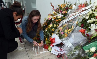 Des touristes allument des bougies le 27 mars 2015 devant le Musée national du Bardo à Tunis à la mémoire des 21 personnes tuées dans l'attaque jihadiste du 18 mars